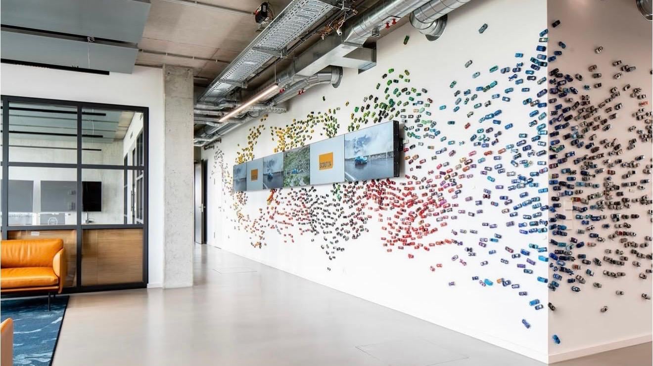 Großflächig gestaltete, weiße Wand in einem modernen Büroflur